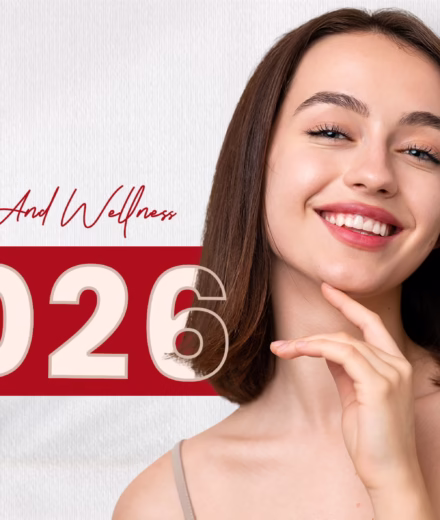Smiling woman with straight brown hair poses against a split red and white background with "2026" and "Beauty and Wellness" text.